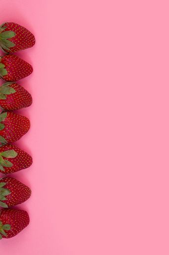 A top view of fresh strawberries frame on pink background