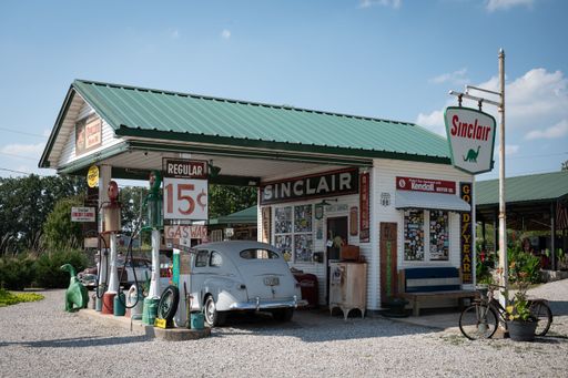 The white, classic Ford Super Deluxe car at the old gas station in the daytime