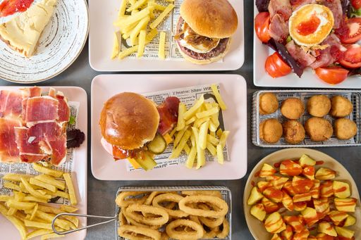 An overhead view of a rectangular table covered with a variety of trays containing diverse dishes