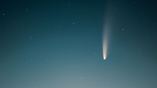 An awe-inspiring shot of a comet streaking across a star-studded night sky