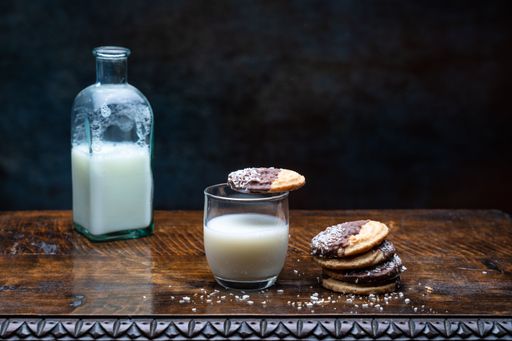 A closeup shot of a glass of milk and cookies on the table
