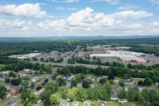 An aerial view of a city and vast landscape under a bright cloudy day