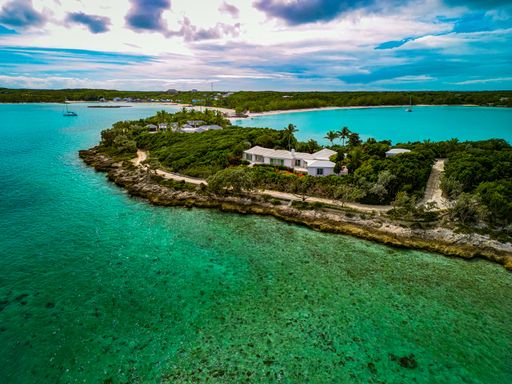 An aerial view of a beautiful island with green trees and turquoise sea