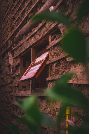 A vertical shot of open wooden window frame on old grunge wall