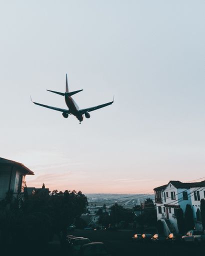 A vertical shot of an airplane flying over a city