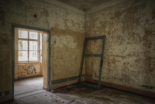 An empty room with a frame door inside of an old house