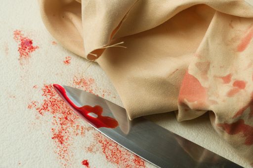 A closeup shot of a bloody knife and a wipe on the white background