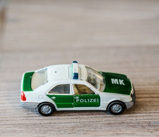 Siku toy police model car on a wooden surface.