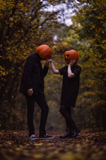 This whimsical couple dressed as Jack and Jill on their heads with pumpkins on them is a delightful addition to any fall or Halloween decor