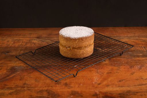 A closeup of a freshly baked biscuit with chocolate cream and sugar powder
