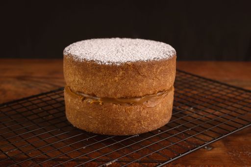 A closeup of a freshly baked biscuit with chocolate cream and sugar powder