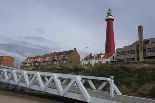 A low angle shot of a red lighthouse at  Scheveningen Beach in  Scheveningen Netherlands