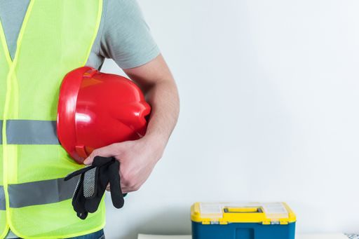 A closeup shot of an Architect, constructor with a helmet under his arm.