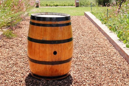 A round wooden barrel in the middle of a field