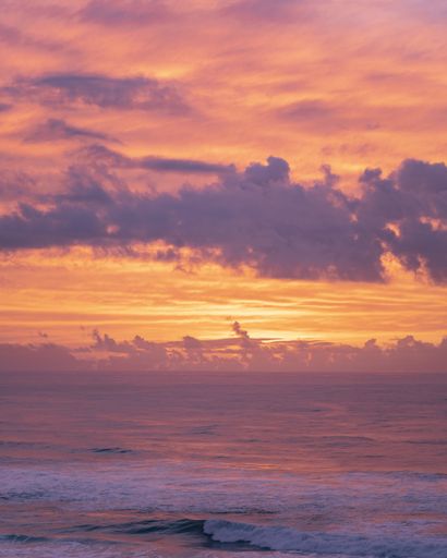 A vertical shot of the mesmerizing sunset over the endless ocean