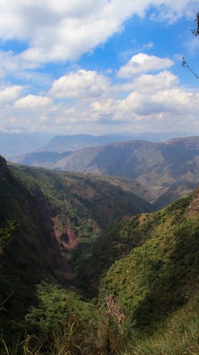 A vertical shot of the scenic hills under the cloudy sky
