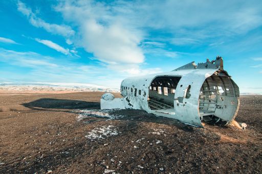 An abandoned aircraft wrecks under a cloudy sky