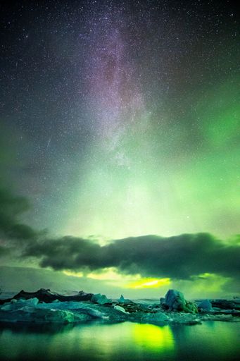 A breathtaking view of Aurora Borealis over the Jokulsarlon lagoon with milky way on top