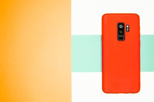 A top view of a phone with a red case on a colorful background