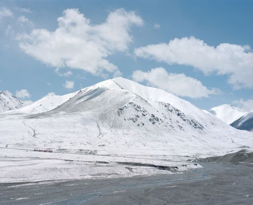 A snow-capped mountain range is on the other side of a river in this stock photo