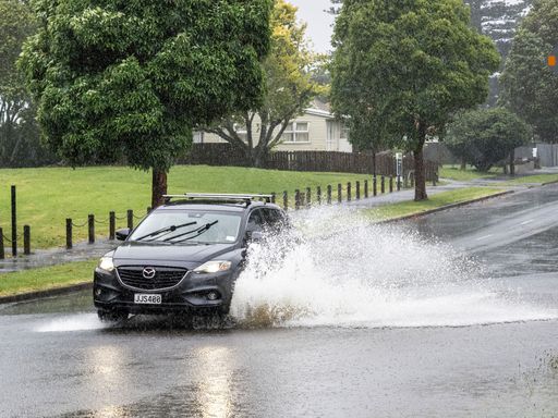 This car was caught in a puddle on the street and it's getting wet!