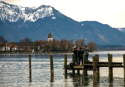 A group of tourists standing of a wooden pier and admiring the amazing view from the river