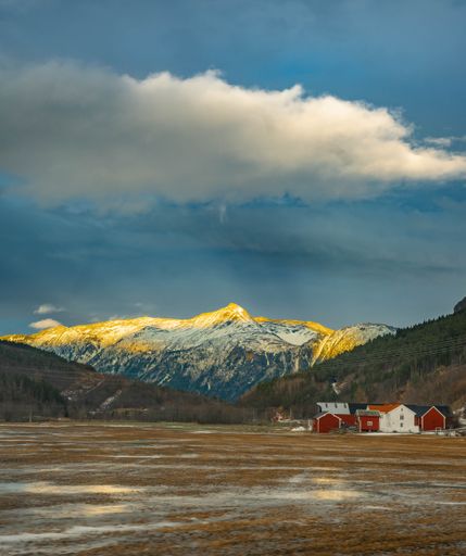 A vertical shot of beautiful rural houses near the Sunndal Mountains in Norway