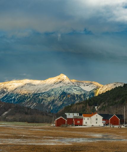 A vertical shot of beautiful rural houses near the Sunndal Mountains in Norway