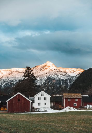 A vertical shot of beautiful rural houses near the Sunndal Mountains in Norway