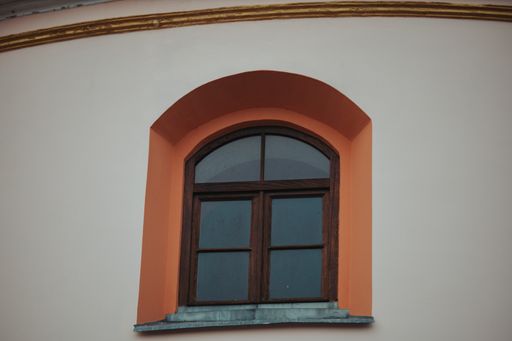 A low angle shot of an arch-shaped window of a building