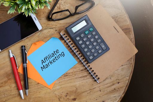 A top view of Affiliate Marketing message on paper notes with pens, calculator on the notebook