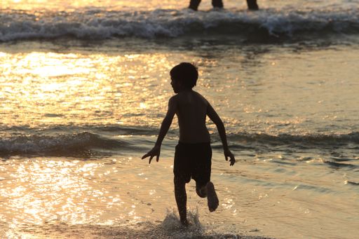 a boy running forward towards beach with happiness.