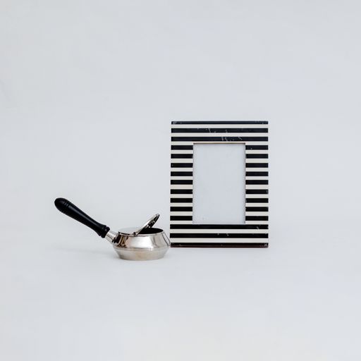A closeup shot of portafilter with lid and a striped photo frame with copy space