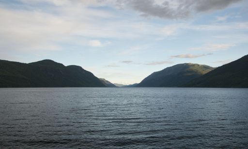 This stunning view of a mountain valley from across the water on a bright, sunny day is perfect for a stock photo agency