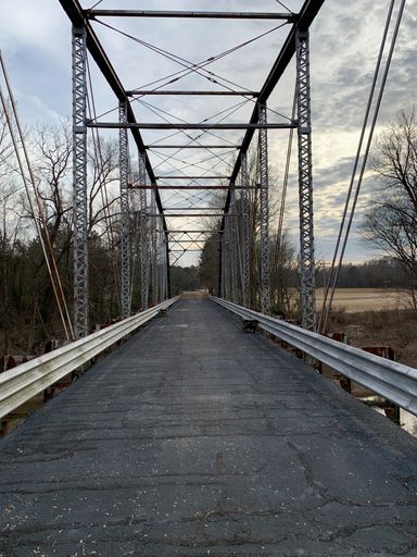 A vertical shot of a historic metal bridge in rural North Carolina captured during the daytime
