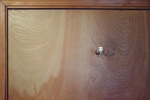 A wooden wall with a silver coat hanger