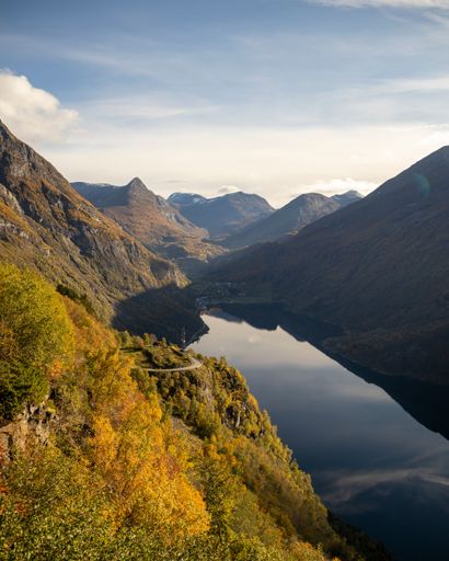 A vertical shot of a beautiful flowing river through mountains in Geiranger, Norway