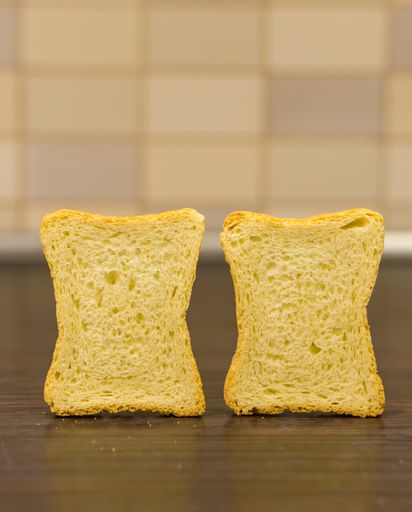 A vertical shot of sliced toast bread on a wooden surface
