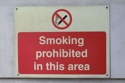 This image shows a red sign which states "No Smoking or Prohibited in This Area"