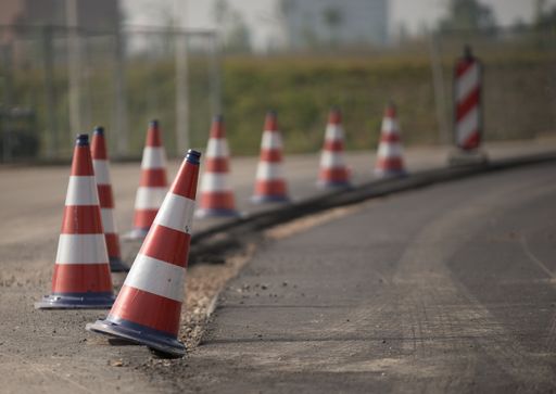 Several red and white roadblocks next to each other during daytime