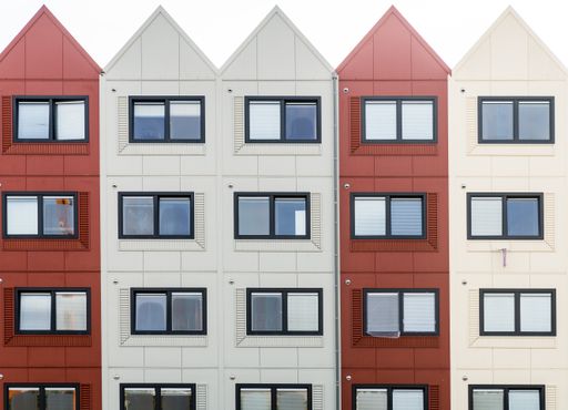 A closeup shot of a building with red and white sections and triangular roofs