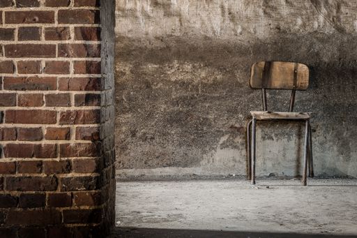 An old single wooden chair inside an abandoned building - depression solitude cocnept