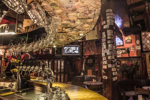 The interior design of a cosy Irish pub decorated with different currencies