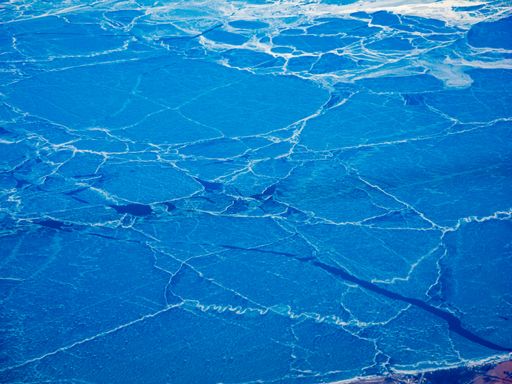 Aerial view of a frozen Lake Eerie with cracks across the frozen lake surface