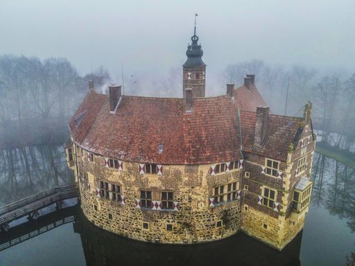 An aerial shot of the Vischering Castle in Ludinghausen captured on a foggy day