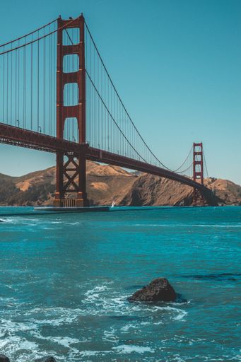 A vertical shot of the beautiful Golden Gate Bridge and amazing clear blue sky in the background
