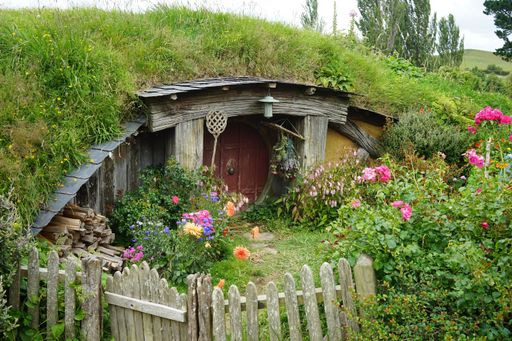 A beautiful shot of a building in the hill covered by grass and flowers