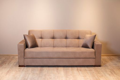 A closeup shot of a beige sofa with two pillows in a studio - perfect for background