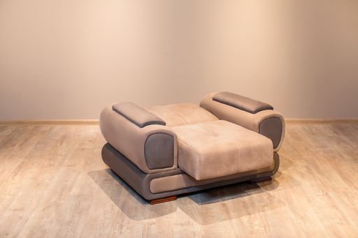 A closeup shot of a single brown sofa on a wooden floor