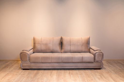 A closeup shot of a brown couch on a wooden floor